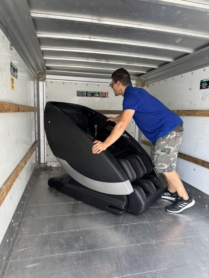 Toro mover lifting a massage chair into a truck